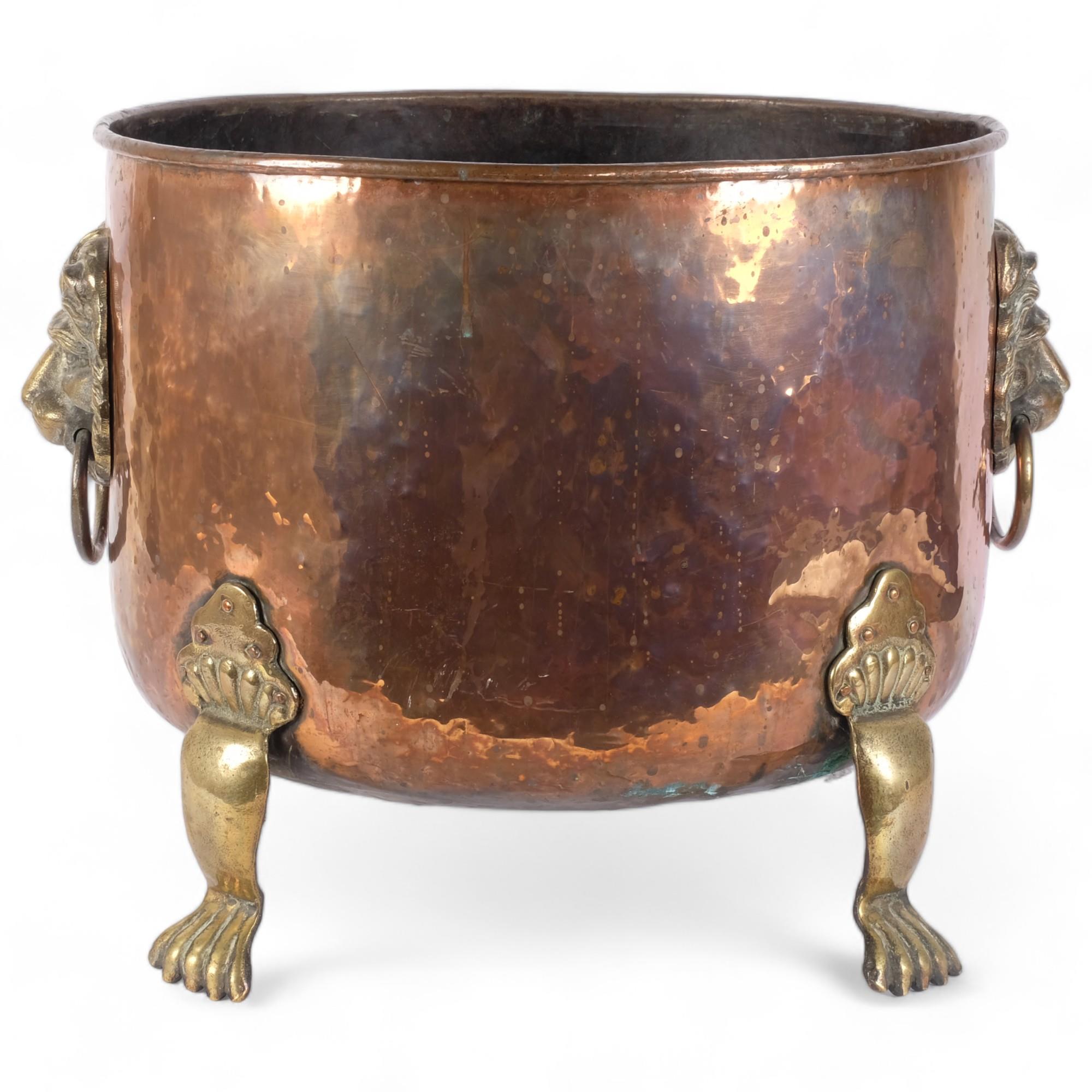 A large Victorian hammered copper jardiniere, with cast-brass lion mask ring handles, and brass