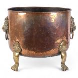 A large Victorian hammered copper jardiniere, with cast-brass lion mask ring handles, and brass
