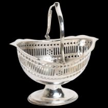 A 20th century silver plated swing-handle bon bon dish on foot, with pierced decoration