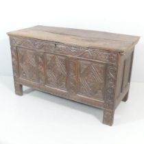 A 17th century panelled oak coffer, with carved decoration to front, candlebox to interior with