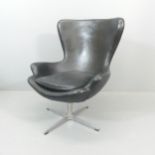 A black faux-leather upholstered egg chair in the manner of Arne Jacobsen.