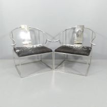A pair of contemporary designer Ming style armchairs in polished steel with ponyskin seats.