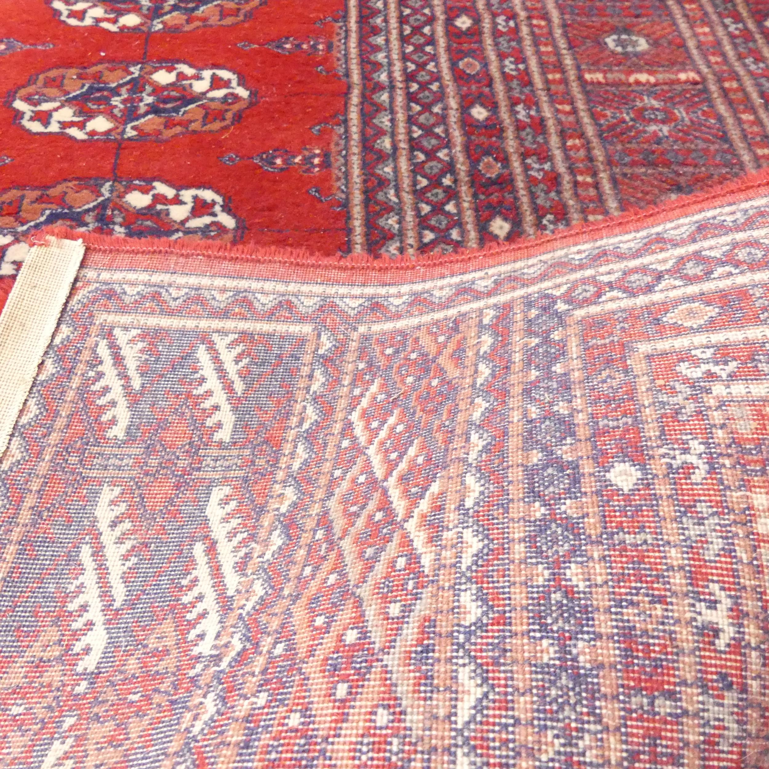 A red-ground machine made Tekke design carpet. 300x200cm. - Image 2 of 2