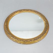 A 19th century gilt-wood and gesso framed oval wall mirror. 92x80cm.
