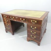 A reproduction mahogany twin-pedestal writing desk, with tooled and embossed green leather skiver