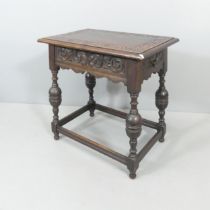 A carved oak side table, with end frieze drawer and all-around stretcher. 69x73x45cm.