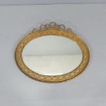 A continental oval gilt-framed bevel edged wall mirror with rope twist decoration. 80x66cm. Fair