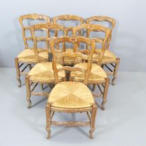 A set of six French oak ladder-back rush-seated dining chairs.