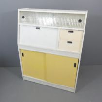 A mid-century kitchen cabinet, fitted with two drawers, fall-front compartment and four sliding