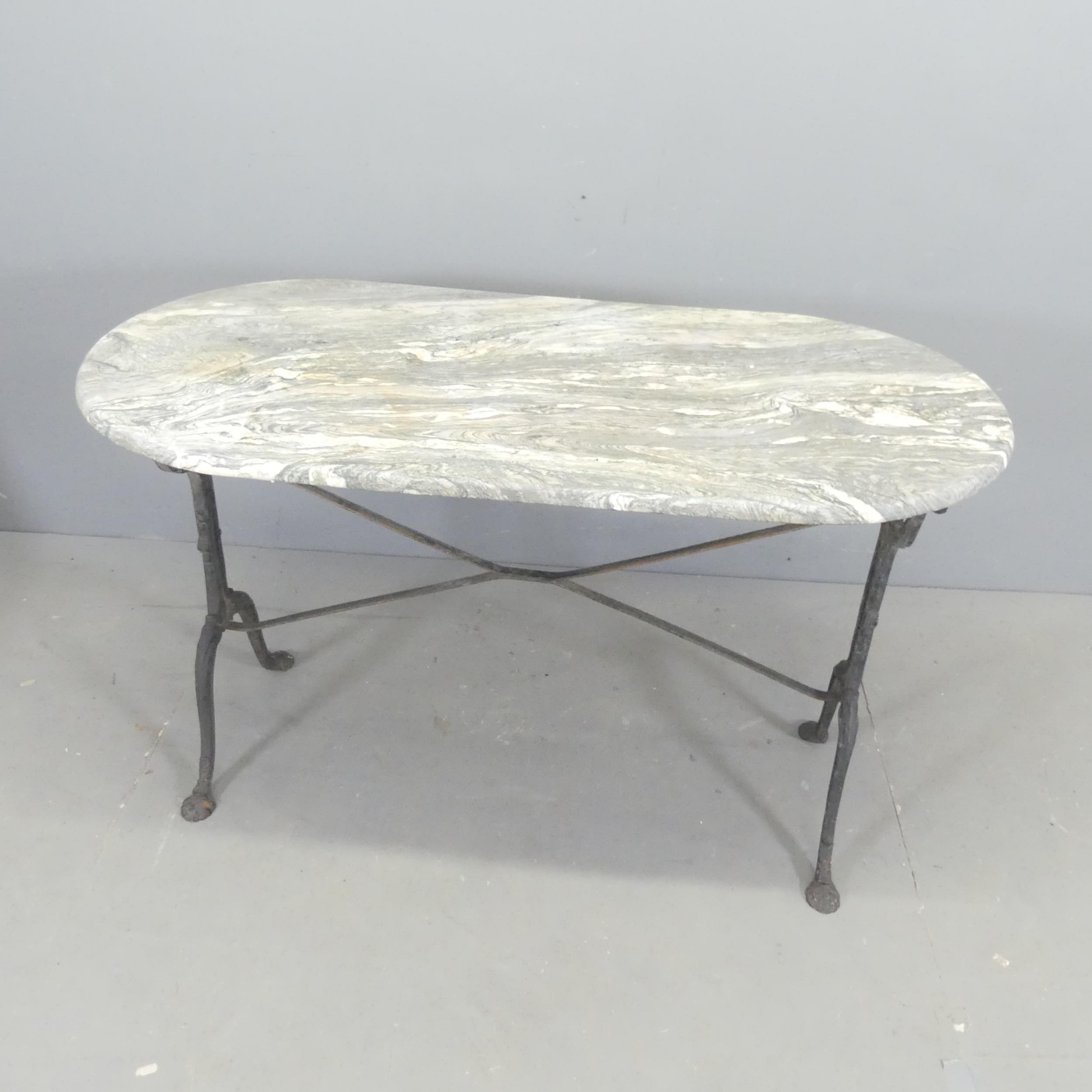 An oval marble-topped garden table on cast-iron frame. 129x72x60cm.