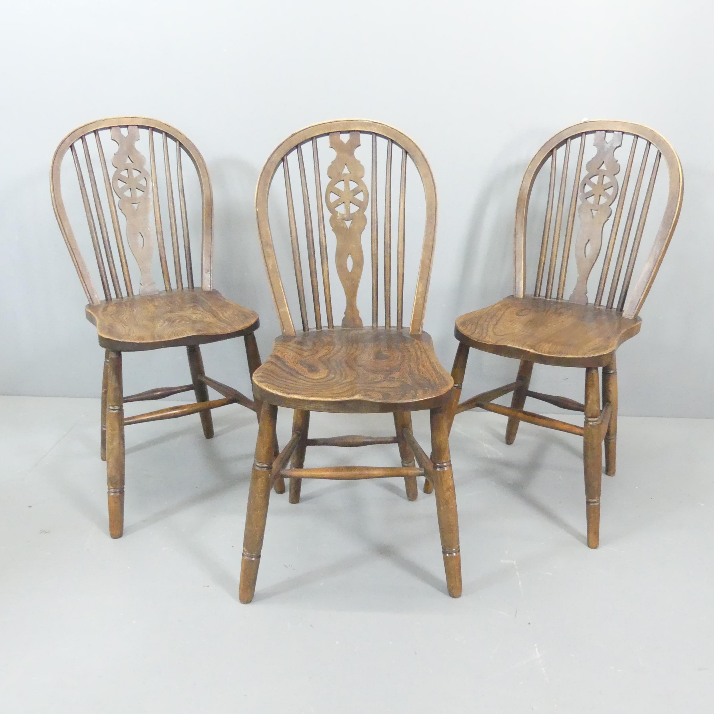 Three 19th century elm-seated wheel back dining chairs. Good condition, with some signs of age and