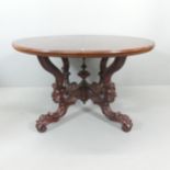 A Victorian mahogany circular topped dining table, raised on profusely carved base. 122x72cm.