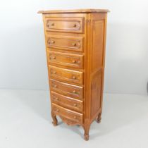 A French cherry wood narrow Semainier chest of seven drawers. 58x132x43cm.