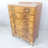 A 1930s mahogany chest of five long drawers, with walnut veneered drawer fronts, raised back and
