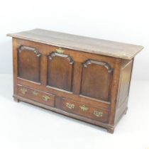 An 18th century oak mule chest, the lifting lid revealing an open interior with fitted candle box,