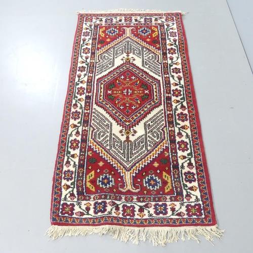A red-ground Persian design rug. 150x77cm.