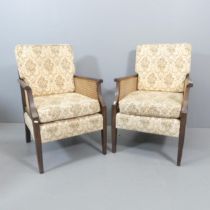 A pair of oak and upholstered Bergere lounge chairs in the Regency manner, with cane panelled