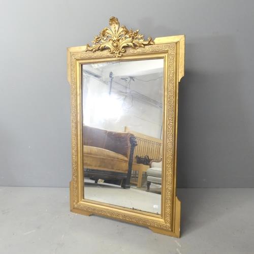 A modern continental style gilt-painted wall mirror with carved decoration. 69x112cm.