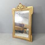 A modern continental style gilt-painted wall mirror with carved decoration. 69x112cm.