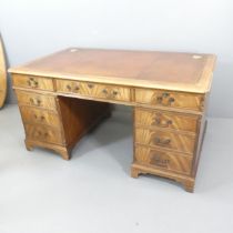 A modern mahogany and oak twin-pedestal partners' writing desk, with tooled and embossed brown