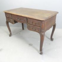 A French oak centre-standing kneehole writing table, with five drawers, cabriole legs and dummy