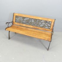 A modern pine slatted garden bench, with inset gilt-resin foliate panel to back. Overall