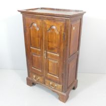 An oak hall cabinet, with two fielded panelled doors with drawers under, and raised on bracket feet.