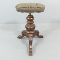 A Victorian oak rise-and-fall piano stool, with turned central column and tripod base. Height (