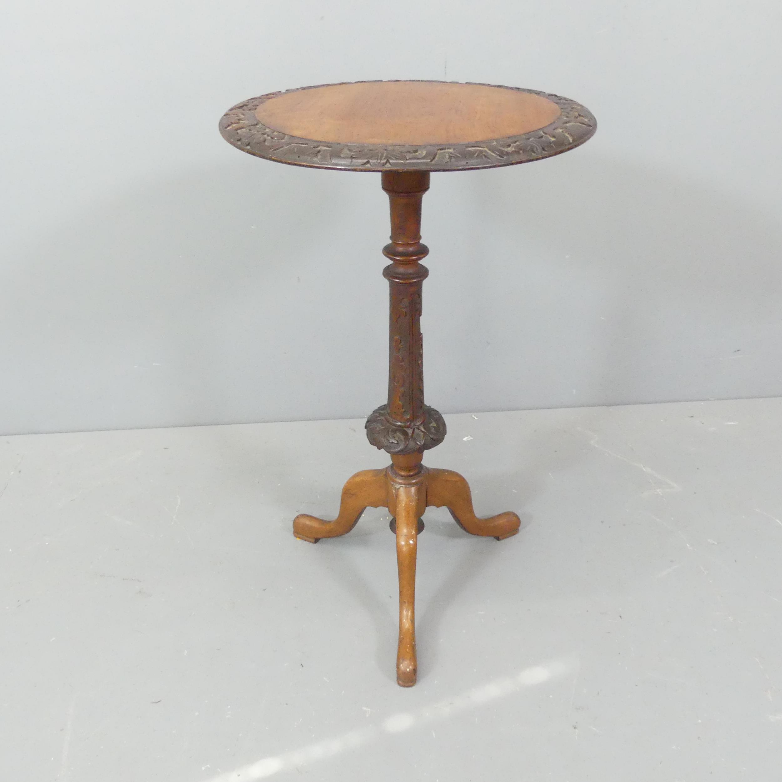 A Victorian mahogany and walnut circular topped occasional table, with carved decoration and
