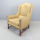 An early 20th century French oak and upholstered armchair. Tear to upholstery to back, and also