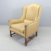 An early 20th century French oak and upholstered armchair. Tear to upholstery to back, and also