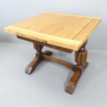 An early 20th century oak draw-leaf dining table, raised on carved baluster legs with H-shaped