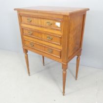 A French mahogany chest of three long drawers, raised on turned legs with fluted decoration.