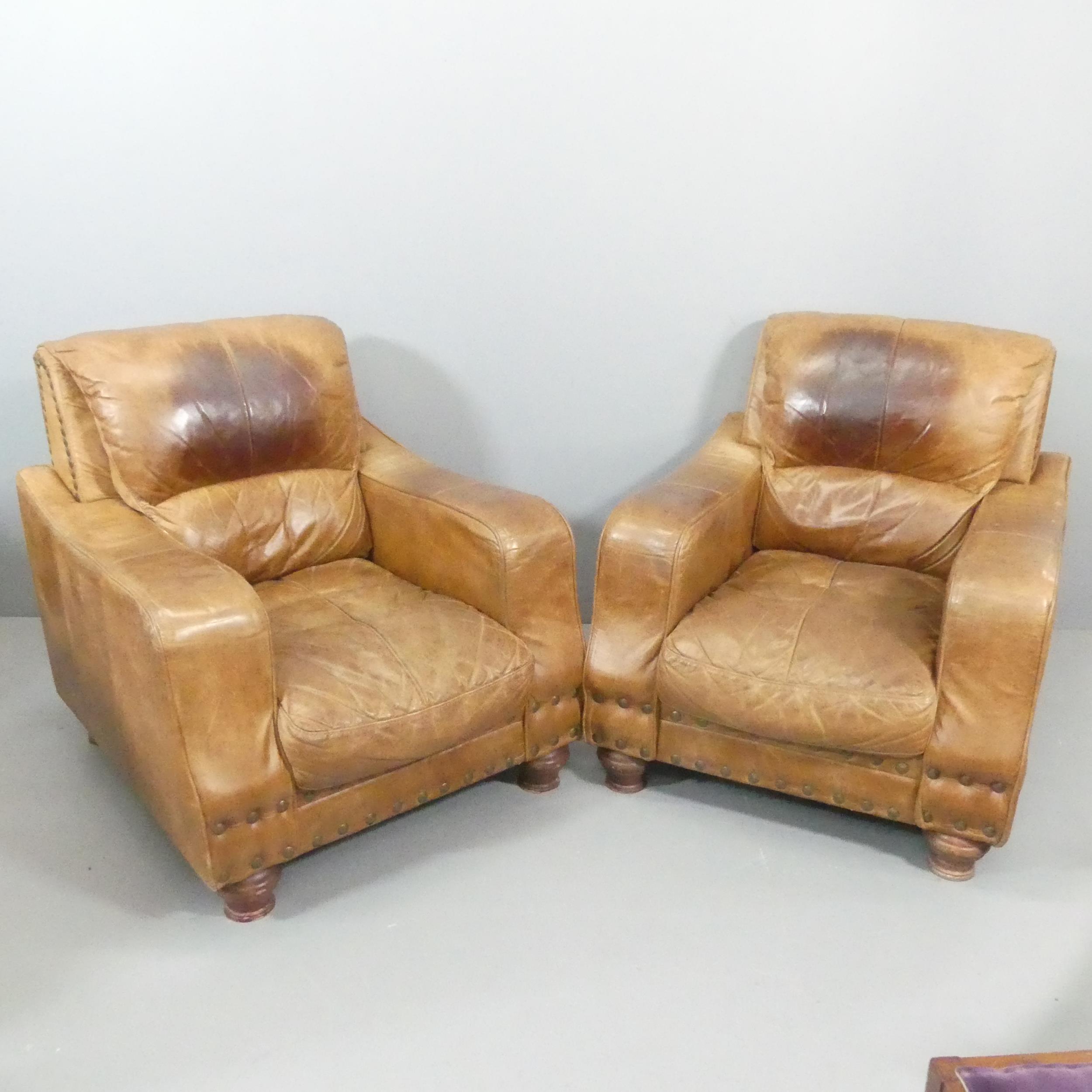 A pair of brown studded-leather upholstered club armchairs. Overall 85x94x94cm, seat 48x40x60cm.