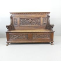 A 19th century oak hall bench, with all over carved decoration and lifting storage seat.