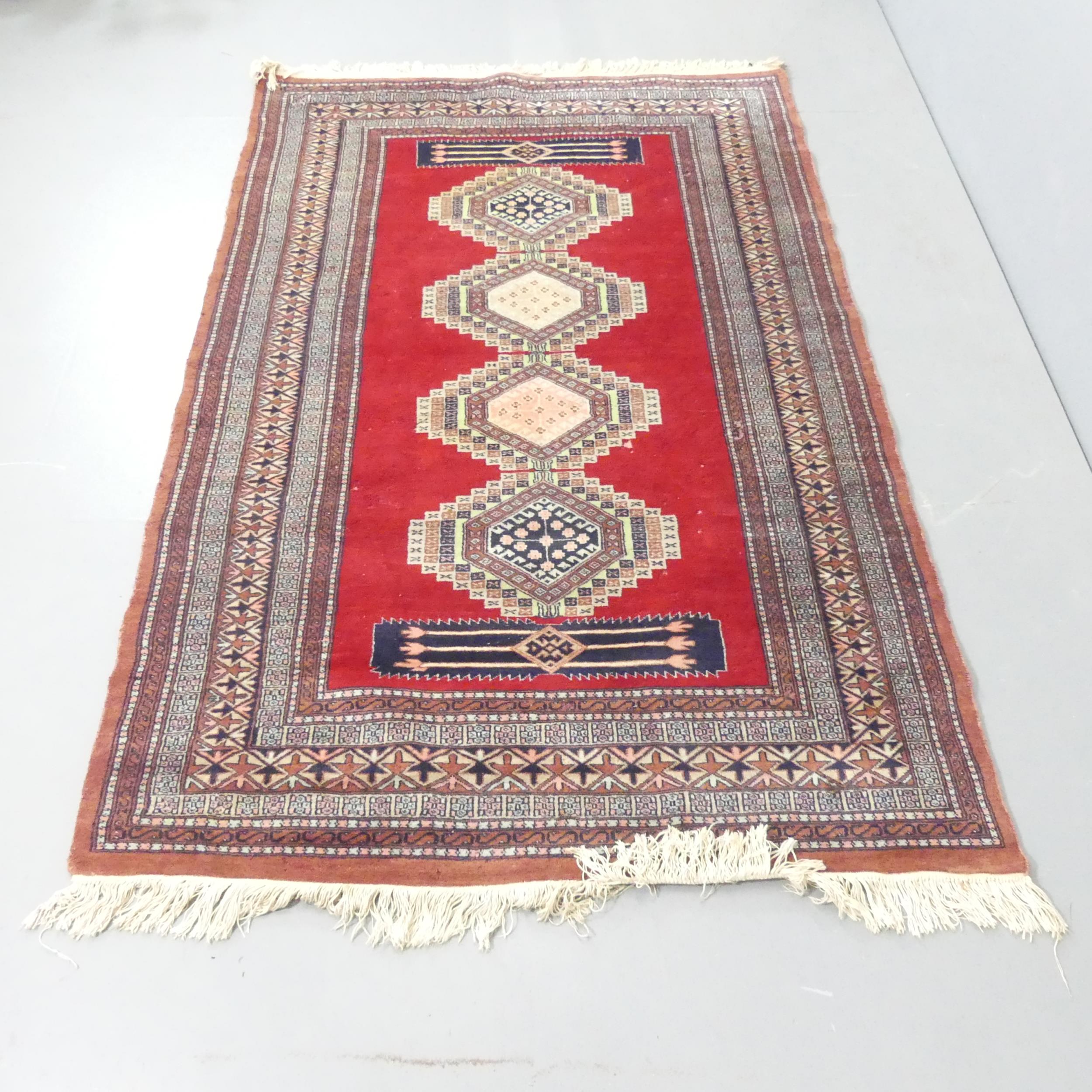 A handmade red ground Uzbek Bokhara rug. 205x130cm.