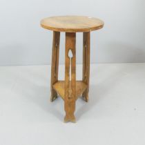 An Arts & Crafts oak two-tier occasional table, with pierced decoration. 36x69cm.