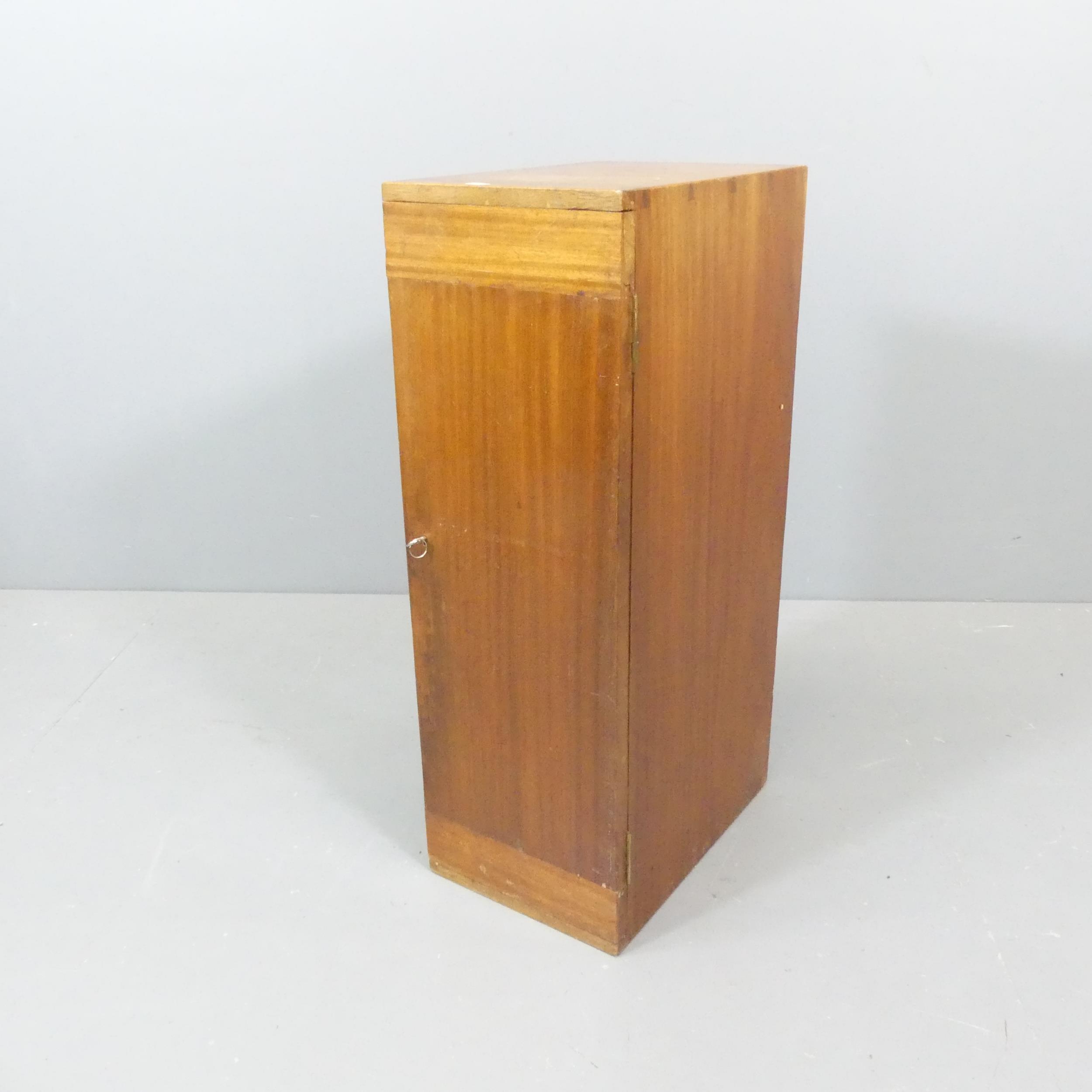 A vintage teak filing chest of small proportions, the locking door concealing 6 drawers with