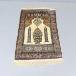 A silk cream-ground Persian prayer mat. 125x80cm.