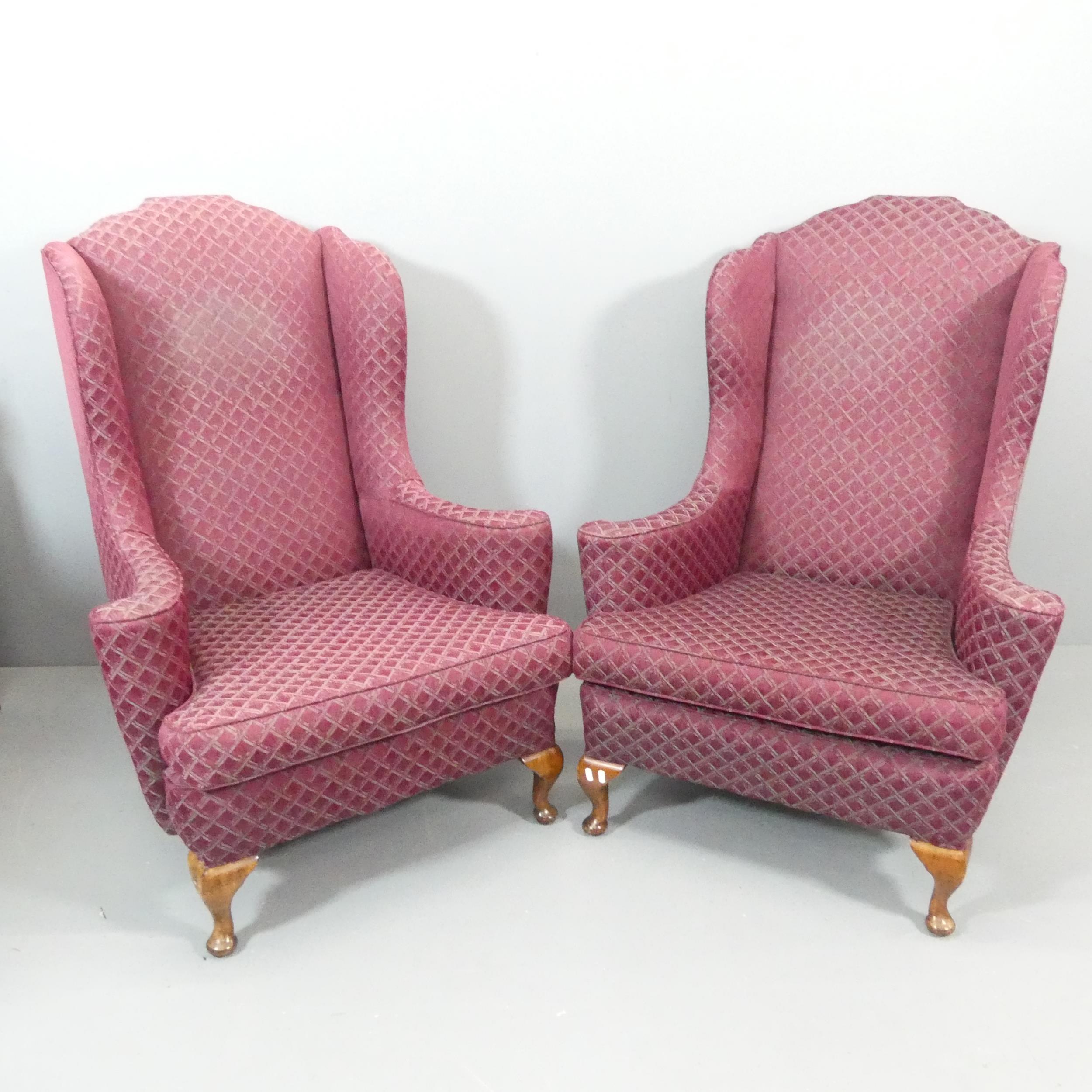 A pair of 1940s mahogany and upholstered wingback armchairs. Some marks to upholstery, and scratches