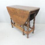 An early 20th century oak oval gate-leg drop-leaf table with barley twist supports. 92x74x37cm.