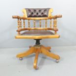 A reproduction Victorian style pine and faux-leather upholstered swivel desk chair.