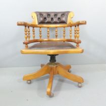 A reproduction Victorian style pine and faux-leather upholstered swivel desk chair.
