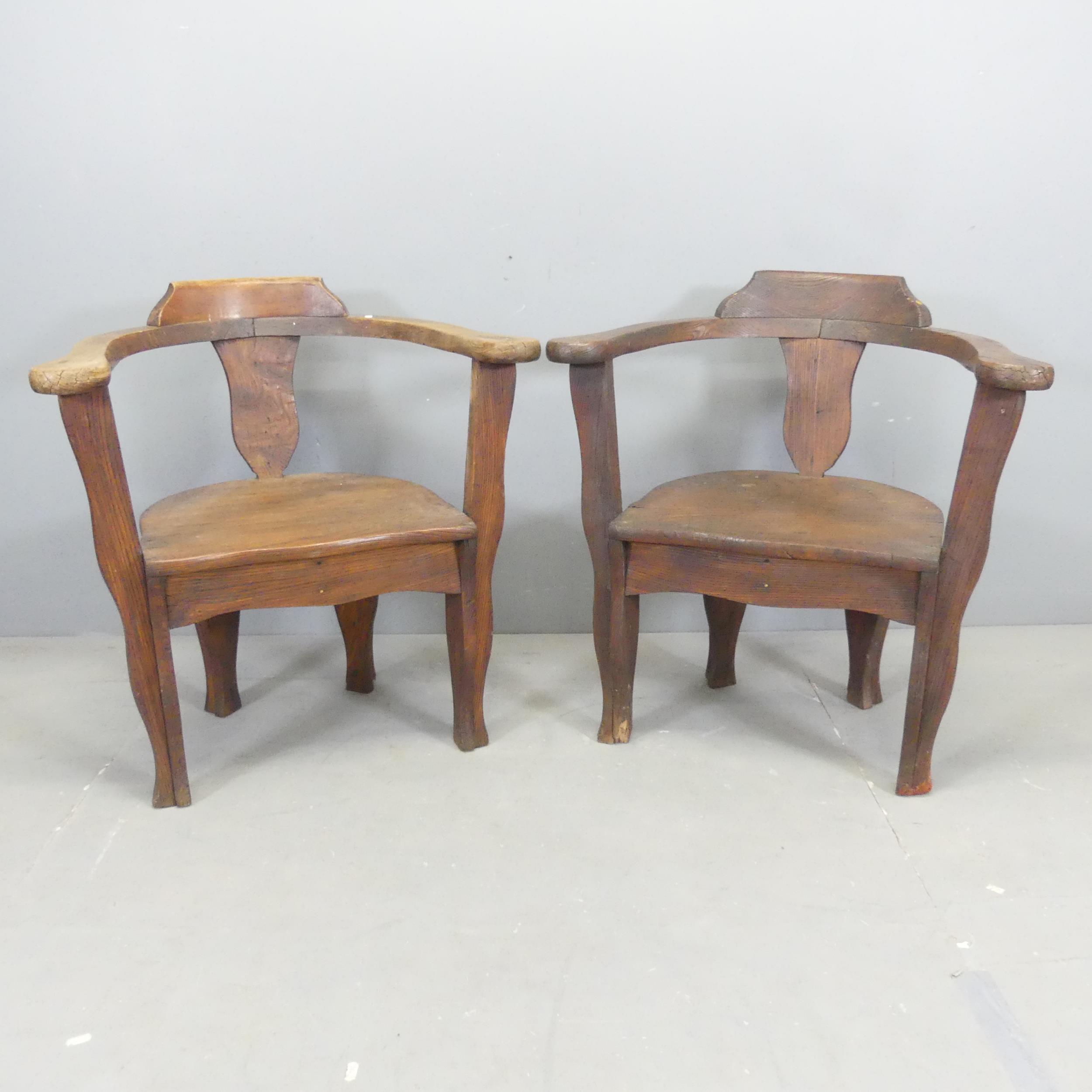 A pair of oak and pine bow-arm captain's chairs.