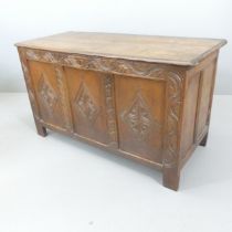 A 19th century panelled oak coffer, with carved decoration and raised on stile legs. 114x66x49cm.