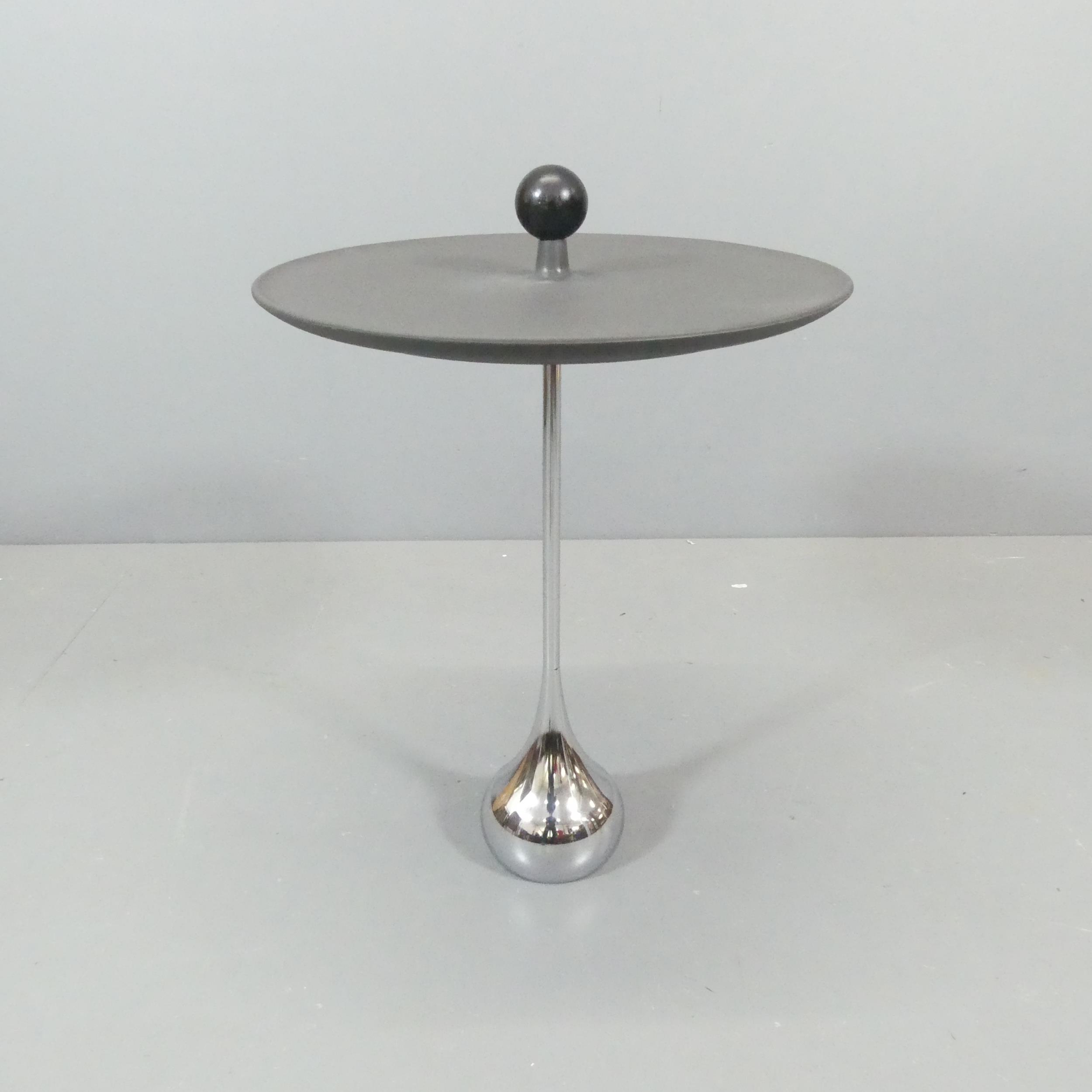 A contemporary designer side table, the rubber top with wooden ball to centre, on heavy chrome