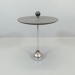 A contemporary designer side table, the rubber top with wooden ball to centre, on heavy chrome