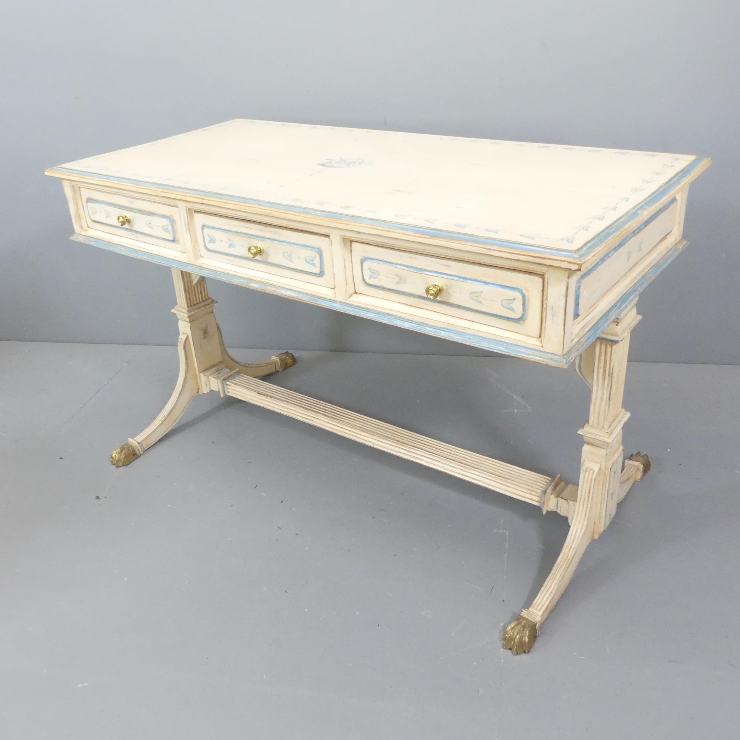 A painted mahogany Regency-style stretcher table, with three drawers and carved decoration.