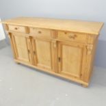 A modern pine Victorian style dresser base, with three drawers above three cupboard doors.