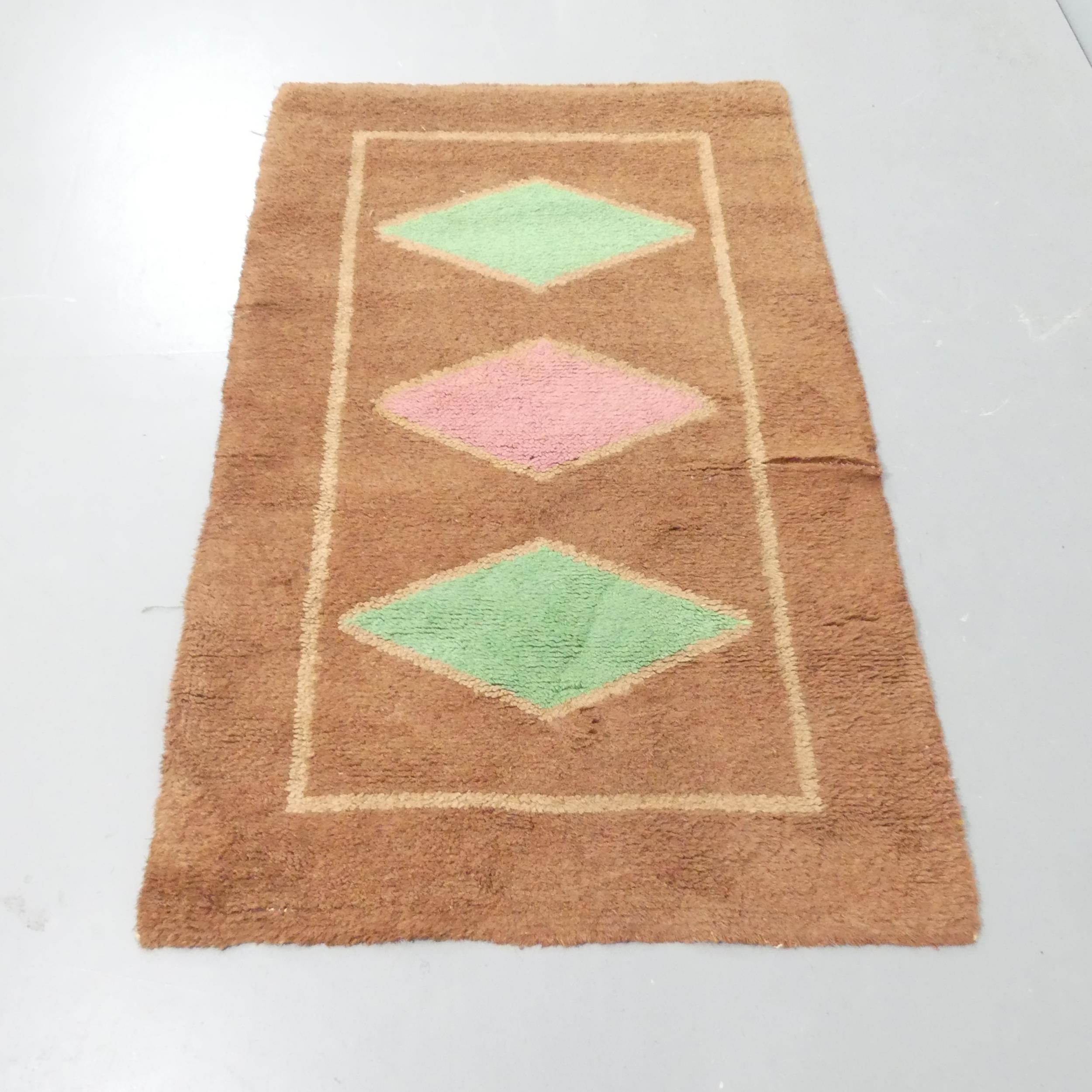 A mid-century hand tufted rug with geometric motifs. 150x93cm.